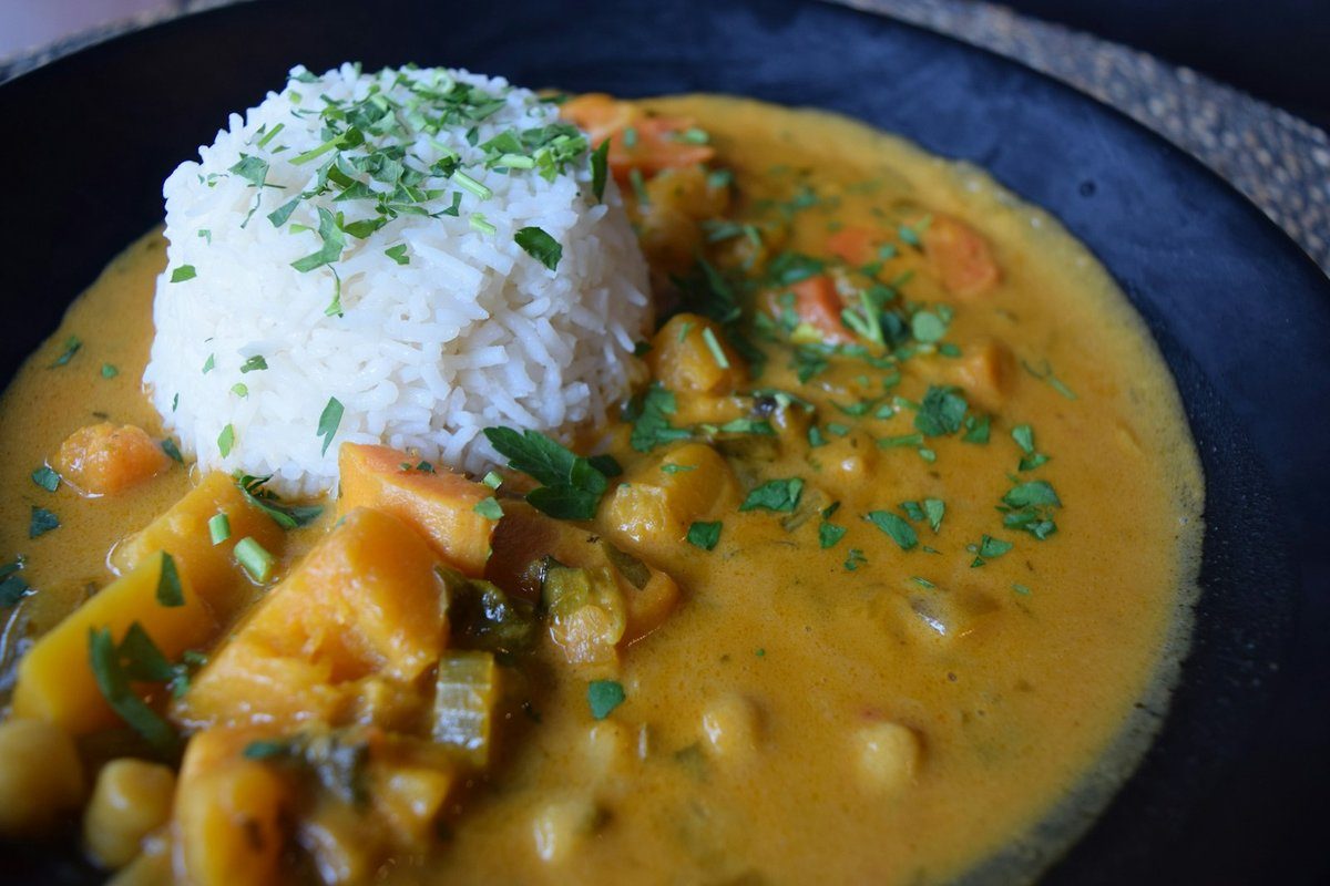 Cari de légumes et de pois chiches servi avec un dôme de riz blanc